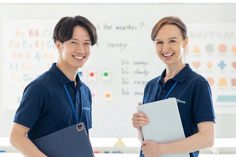 紺色のポロシャツを着た二人の笑顔のキュリオキッズの講師陣