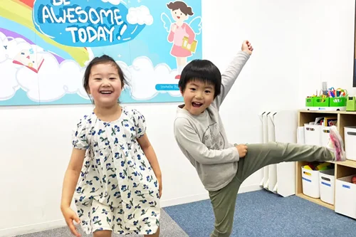 キュリオキッズの教室で楽しそうにポーズする二人の子供たち